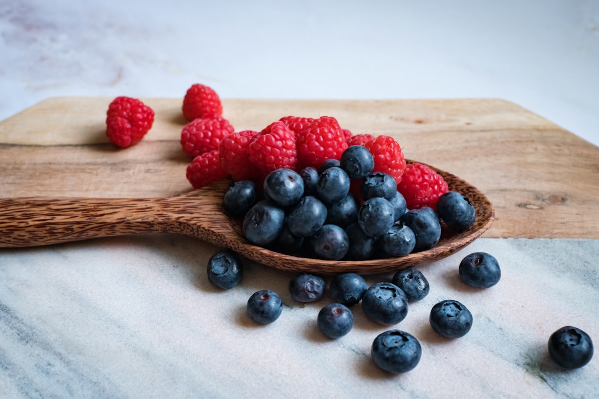 Frutta ricca di fibre - mele, pere, bacche e frutti di bosco su un tavolo di legno